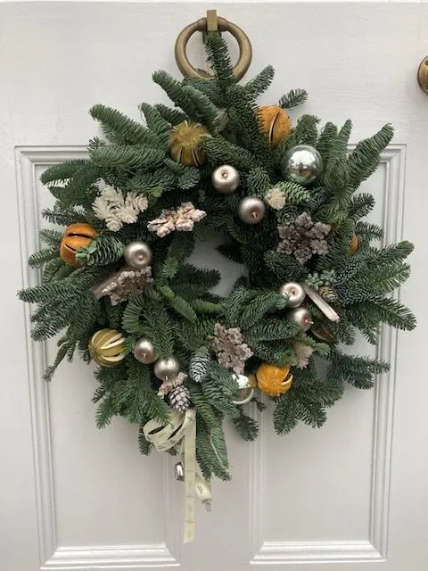A christmas wreath hanging on a door.